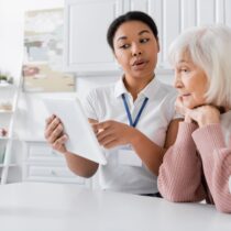 acompanhante auxiliando idosa em consulta médica com orientação profissional
