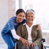 Atendimento domiciliar para idosos com cuidadora auxiliando idosa em casa com segurança e acolhimento